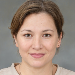 Joyful white young-adult female with medium  brown hair and grey eyes