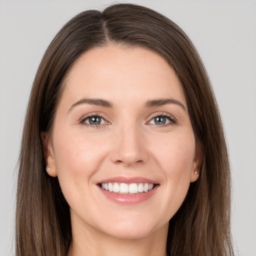 Joyful white young-adult female with long  brown hair and grey eyes