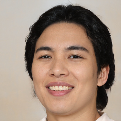 Joyful asian young-adult male with medium  black hair and brown eyes