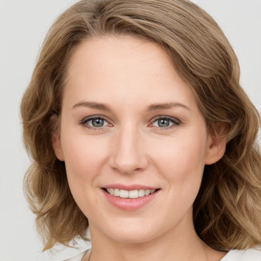 Joyful white young-adult female with medium  brown hair and grey eyes