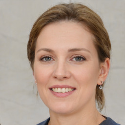 Joyful white young-adult female with medium  brown hair and blue eyes