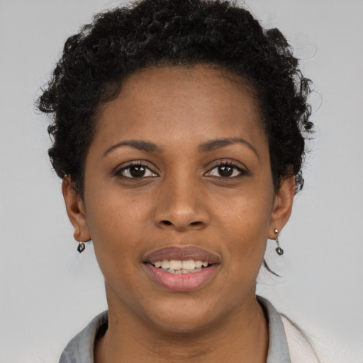 Joyful black young-adult female with short  brown hair and brown eyes