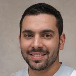 Joyful white young-adult male with short  black hair and brown eyes