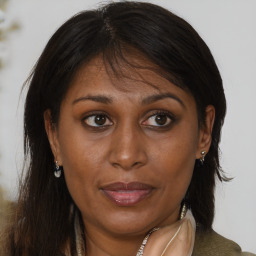 Joyful black adult female with medium  brown hair and brown eyes