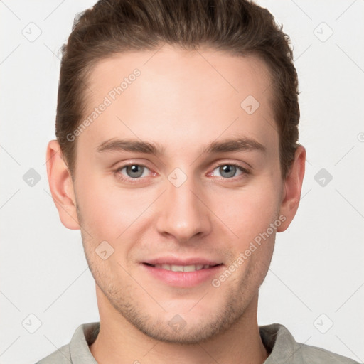 Joyful white young-adult male with short  brown hair and grey eyes