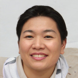 Joyful asian young-adult female with short  brown hair and brown eyes