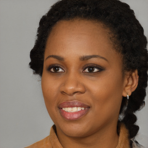 Joyful black young-adult female with long  black hair and brown eyes