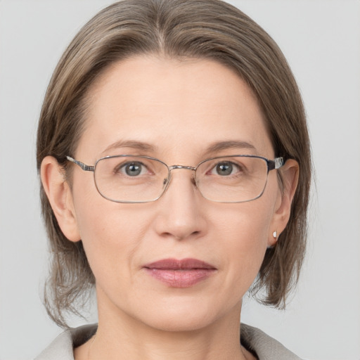 Joyful white adult female with medium  brown hair and grey eyes