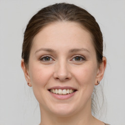 Joyful white young-adult female with medium  brown hair and grey eyes