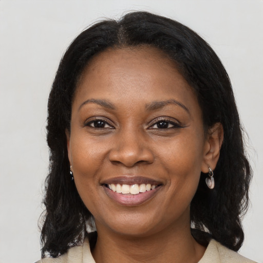 Joyful black young-adult female with long  brown hair and brown eyes