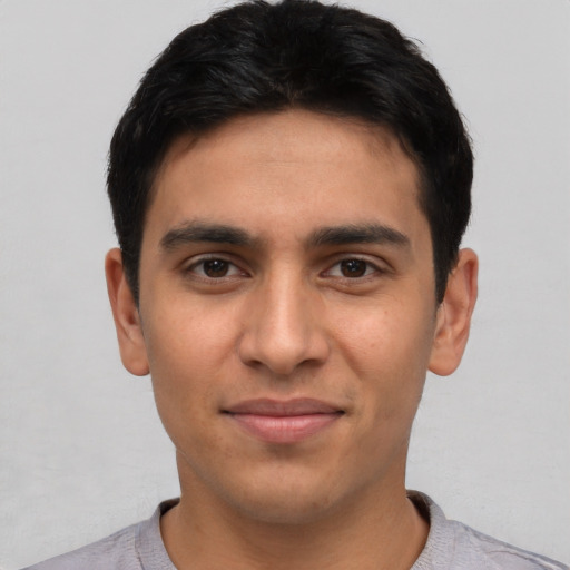 Joyful latino young-adult male with short  black hair and brown eyes