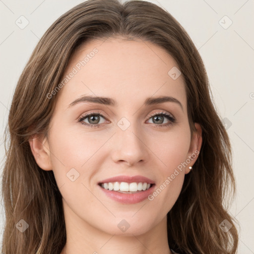 Joyful white young-adult female with long  brown hair and green eyes