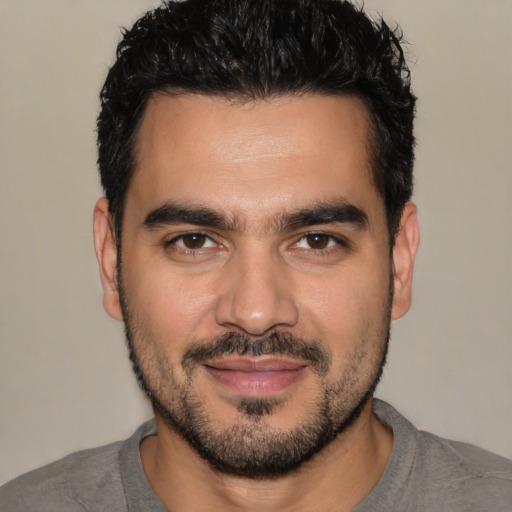 Joyful white young-adult male with short  black hair and brown eyes
