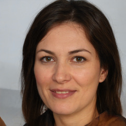 Joyful white adult female with medium  brown hair and brown eyes