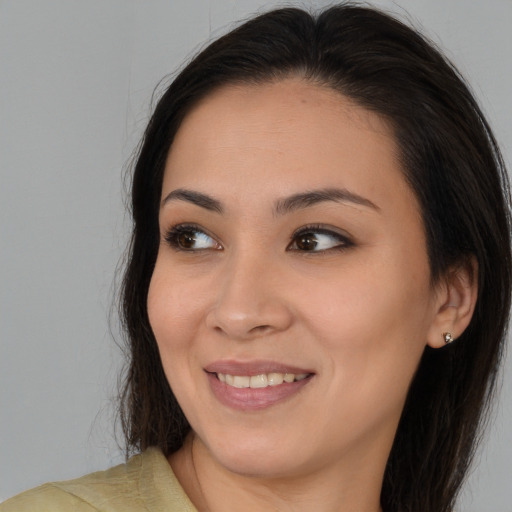 Joyful asian young-adult female with long  brown hair and brown eyes