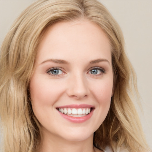 Joyful white young-adult female with long  brown hair and blue eyes