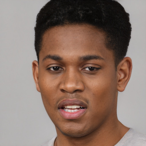 Joyful black young-adult male with short  brown hair and brown eyes