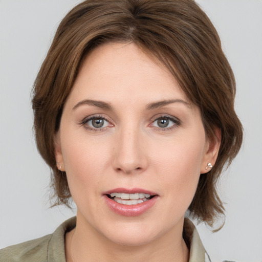 Joyful white young-adult female with medium  brown hair and grey eyes