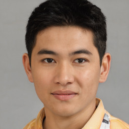 Joyful asian young-adult male with short  brown hair and brown eyes