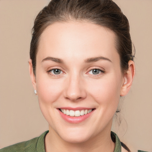 Joyful white young-adult female with short  brown hair and green eyes