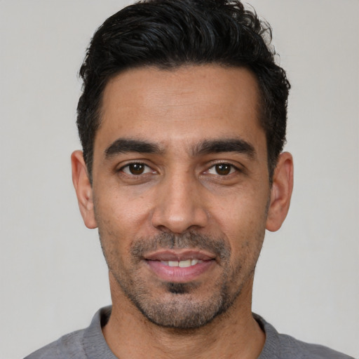 Joyful latino young-adult male with short  black hair and brown eyes