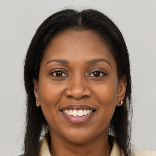 Joyful black young-adult female with long  brown hair and brown eyes