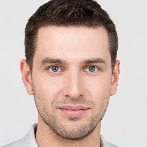 Joyful white young-adult male with short  brown hair and grey eyes