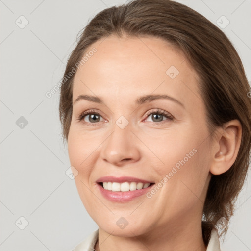 Joyful white adult female with medium  brown hair and grey eyes