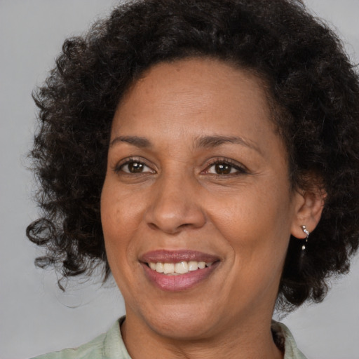 Joyful black adult female with medium  brown hair and brown eyes