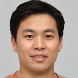 Joyful asian young-adult male with short  brown hair and brown eyes