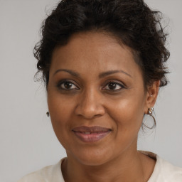 Joyful black adult female with medium  brown hair and brown eyes