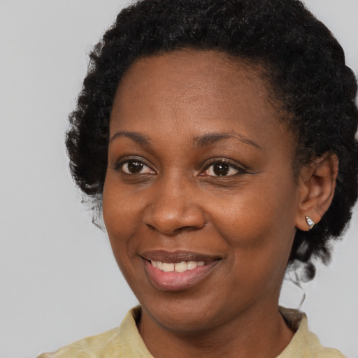 Joyful black adult female with short  brown hair and brown eyes
