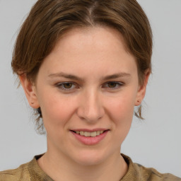 Joyful white young-adult female with medium  brown hair and grey eyes