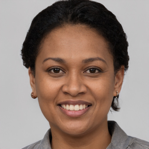 Joyful latino adult female with short  brown hair and brown eyes