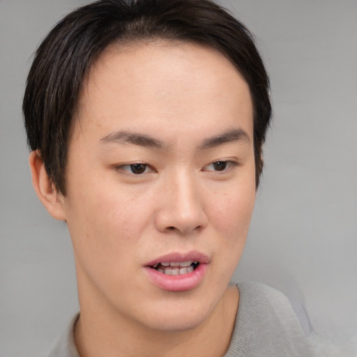 Joyful asian young-adult male with short  brown hair and brown eyes