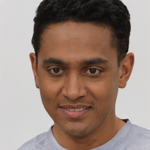 Joyful black young-adult male with short  black hair and brown eyes