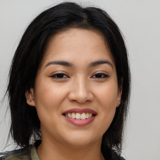 Joyful asian young-adult female with long  brown hair and brown eyes