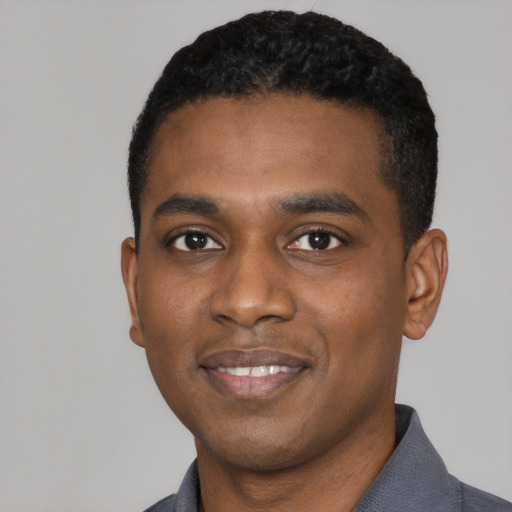 Joyful black young-adult male with short  black hair and brown eyes