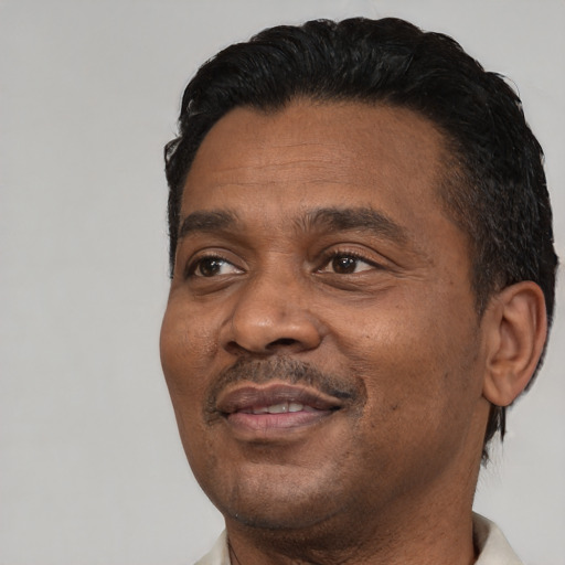Joyful latino adult male with short  black hair and brown eyes