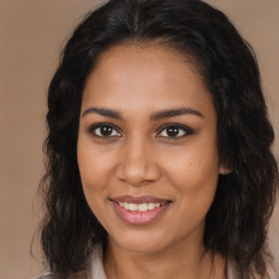 Joyful black young-adult female with long  brown hair and brown eyes