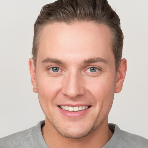 Joyful white young-adult male with short  brown hair and grey eyes