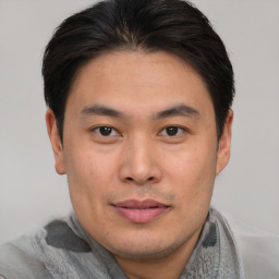 Joyful asian young-adult male with short  brown hair and brown eyes