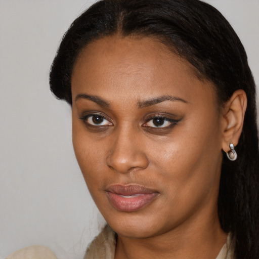 Joyful black young-adult female with long  brown hair and brown eyes