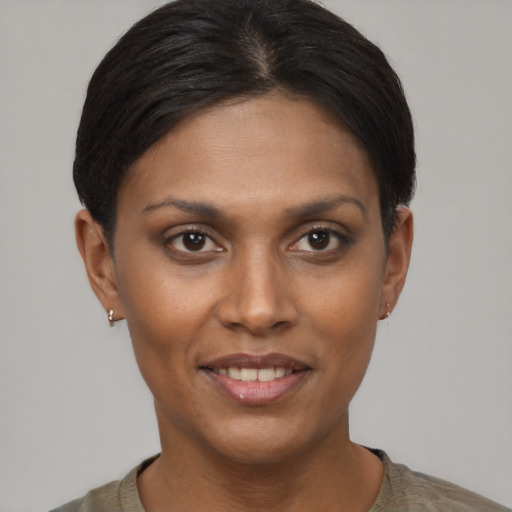 Joyful black young-adult female with short  brown hair and brown eyes