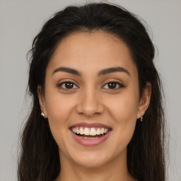 Joyful latino young-adult female with long  brown hair and brown eyes