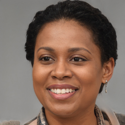 Joyful black adult female with medium  brown hair and brown eyes