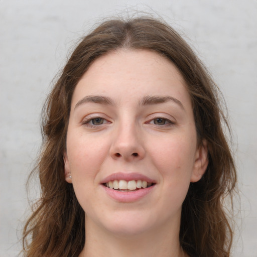 Joyful white young-adult female with long  brown hair and green eyes