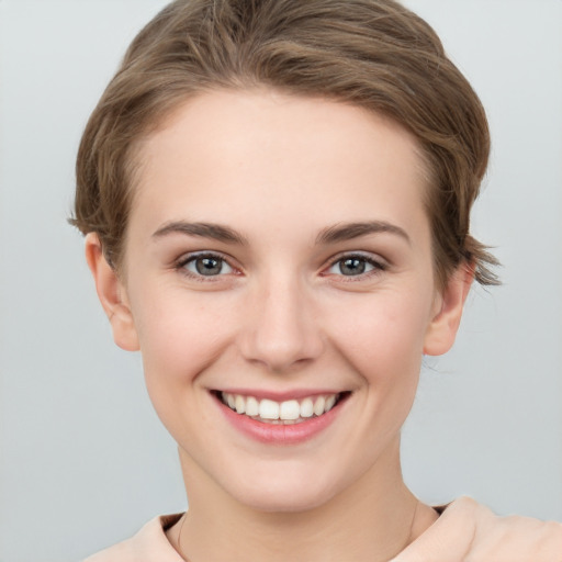 Joyful white young-adult female with short  brown hair and grey eyes