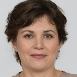 Joyful white adult female with medium  brown hair and brown eyes