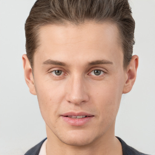 Joyful white young-adult male with short  brown hair and grey eyes